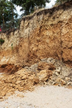 Karadeniz kıyısındaki heyelan bölgesi. Deniz taşı kabuğu. Yağmur mevsiminde doğal afetler bölgesi. Büyük toprak kütleleri tepenin yamacında kayıp evleri yok ediyor. Heyelan - yaşam tehdidi