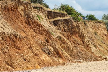 Karadeniz kıyısındaki heyelan bölgesi. Deniz taşı kabuğu. Yağmur mevsiminde doğal afetler bölgesi. Büyük toprak kütleleri tepenin yamacında kayıp evleri yok ediyor. Heyelan - yaşam tehdidi