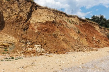 Karadeniz kıyısındaki heyelan bölgesi. Deniz taşı kabuğu. Yağmur mevsiminde doğal afetler bölgesi. Büyük toprak kütleleri tepenin yamacında kayıp evleri yok ediyor. Heyelan - yaşam tehdidi