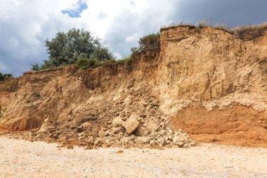 Karadeniz kıyısındaki heyelan bölgesi. Deniz taşı kabuğu. Yağmur mevsiminde doğal afetler bölgesi. Büyük toprak kütleleri tepenin yamacında kayıp evleri yok ediyor. Heyelan - yaşam tehdidi