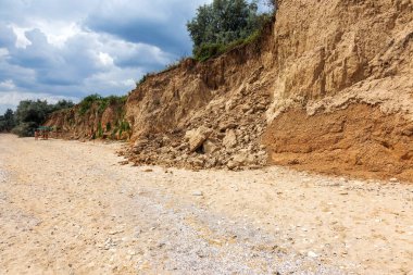Karadeniz kıyısındaki heyelan bölgesi. Deniz taşı kabuğu. Yağmur mevsiminde doğal afetler bölgesi. Büyük toprak kütleleri tepenin yamacında kayıp evleri yok ediyor. Heyelan - yaşam tehdidi