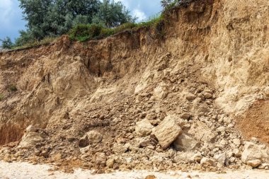 Karadeniz kıyısındaki heyelan bölgesi. Deniz taşı kabuğu. Yağmur mevsiminde doğal afetler bölgesi. Büyük toprak kütleleri tepenin yamacında kayıp evleri yok ediyor. Heyelan - yaşam tehdidi