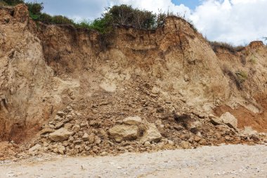Karadeniz kıyısındaki heyelan bölgesi. Deniz taşı kabuğu. Yağmur mevsiminde doğal afetler bölgesi. Büyük toprak kütleleri tepenin yamacında kayıp evleri yok ediyor. Heyelan - yaşam tehdidi