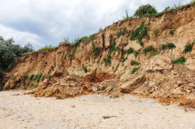 Karadeniz kıyısındaki heyelan bölgesi. Deniz taşı kabuğu. Yağmur mevsiminde doğal afetler bölgesi. Büyük toprak kütleleri tepenin yamacında kayıp evleri yok ediyor. Heyelan - yaşam tehdidi