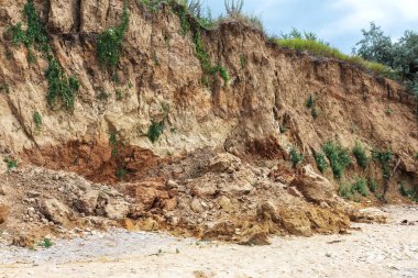 Karadeniz kıyısındaki heyelan bölgesi. Deniz taşı kabuğu. Yağmur mevsiminde doğal afetler bölgesi. Büyük toprak kütleleri tepenin yamacında kayıp evleri yok ediyor. Heyelan - yaşam tehdidi