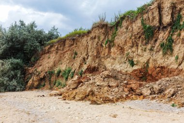 Karadeniz kıyısındaki heyelan bölgesi. Deniz taşı kabuğu. Yağmur mevsiminde doğal afetler bölgesi. Büyük toprak kütleleri tepenin yamacında kayıp evleri yok ediyor. Heyelan - yaşam tehdidi