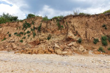 Karadeniz kıyısındaki heyelan bölgesi. Deniz taşı kabuğu. Yağmur mevsiminde doğal afetler bölgesi. Büyük toprak kütleleri tepenin yamacında kayıp evleri yok ediyor. Heyelan - yaşam tehdidi
