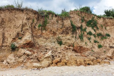 Karadeniz kıyısındaki heyelan bölgesi. Deniz taşı kabuğu. Yağmur mevsiminde doğal afetler bölgesi. Büyük toprak kütleleri tepenin yamacında kayıp evleri yok ediyor. Heyelan - yaşam tehdidi