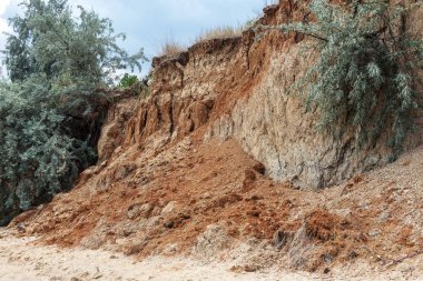 Karadeniz kıyısındaki heyelan bölgesi. Deniz taşı kabuğu. Yağmur mevsiminde doğal afetler bölgesi. Büyük toprak kütleleri tepenin yamacında kayıp evleri yok ediyor. Heyelan - yaşam tehdidi