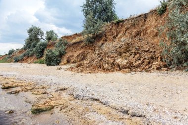 Karadeniz kıyısındaki heyelan bölgesi. Deniz taşı kabuğu. Yağmur mevsiminde doğal afetler bölgesi. Büyük toprak kütleleri tepenin yamacında kayıp evleri yok ediyor. Heyelan - yaşam tehdidi