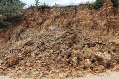 Karadeniz kıyısındaki heyelan bölgesi. Deniz taşı kabuğu. Yağmur mevsiminde doğal afetler bölgesi. Büyük toprak kütleleri tepenin yamacında kayıp evleri yok ediyor. Heyelan - yaşam tehdidi