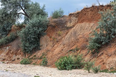 Karadeniz kıyısındaki heyelan bölgesi. Deniz taşı kabuğu. Yağmur mevsiminde doğal afetler bölgesi. Büyük toprak kütleleri tepenin yamacında kayıp evleri yok ediyor. Heyelan - yaşam tehdidi
