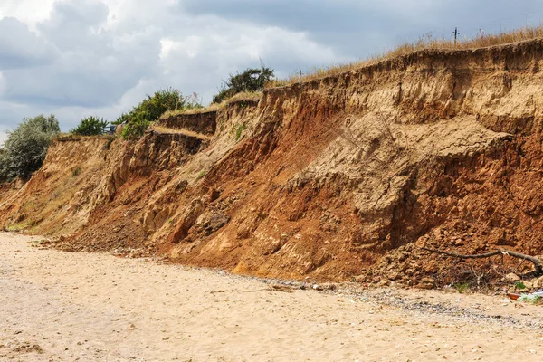 Landslide zone on Black Sea coast. Rock of sea rock shell. Zone of natural disasters during rainy season. Large masses of earth slip along slope of hill, destroy houses. Landslide - threat to life