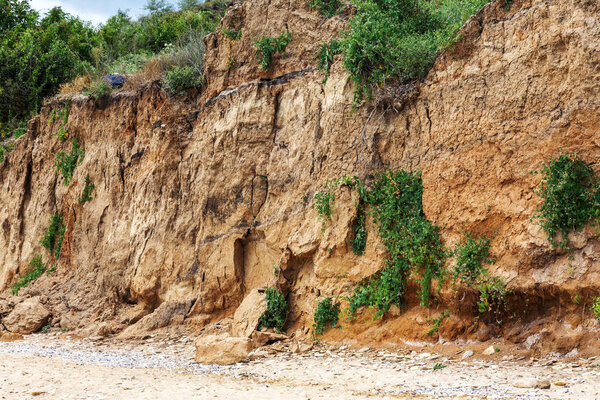 Landslide zone on Black Sea coast. Rock of sea rock shell. Zone of natural disasters during rainy season. Large masses of earth slip along slope of hill, destroy houses. Landslide - threat to life