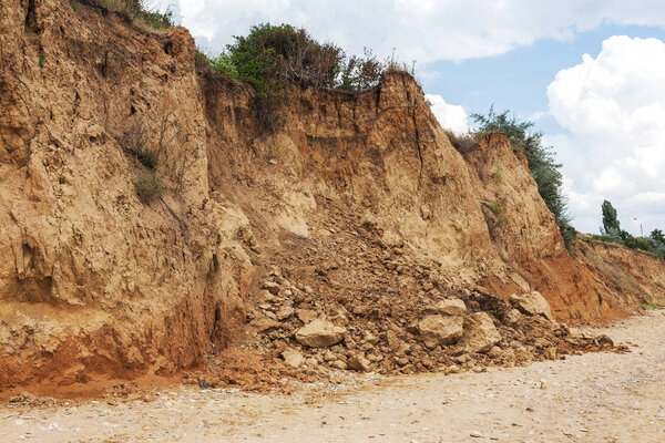 Landslide zone on Black Sea coast. Rock of sea rock shell. Zone of natural disasters during rainy season. Large masses of earth slip along slope of hill, destroy houses. Landslide - threat to life