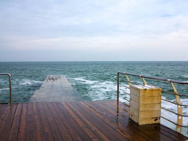 Büyük fırtınalı dalgalar yakınındaki şehir dolgu, dramatik gökyüzü arka plan üzerine çökmesini. Büyük deniz dalga sıçrama. Dev dalgalar üzerinde fırtına