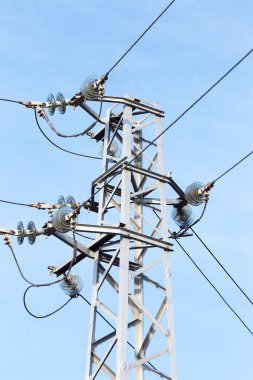 Yüksek gerilim hatları ve güneşli bir düz ve yeşil tarım peyzaj güç pilonlar mavi gökyüzünde cirrus bulutlar ile. Pilon ve iletim güç hattı 
