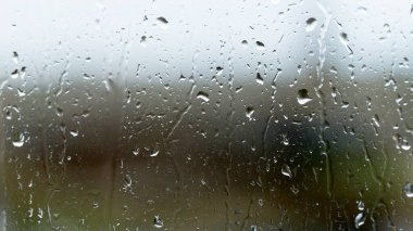 Soyut arkaplan, seçici odaklanma. Camdaki yağmur damlaları. Pencereye püskürt. Yağmurlu hava