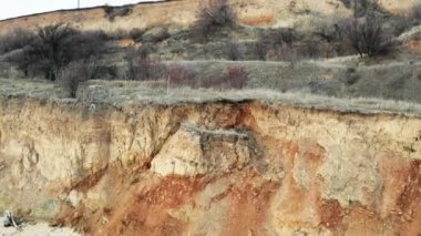 Video heyelan, Karadeniz kıyısındaki kireçtaşı dağlarının dik yamaçlarına kaya düşüşü. Yokuş aşağı kaymak dramatik bir an. Vahşi sahildeki turistler için çığ tehlikesi. Hayati tehlikeler