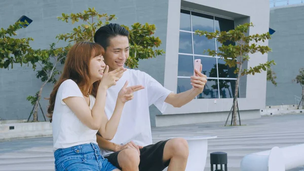 Asian couple using smart phone selfie