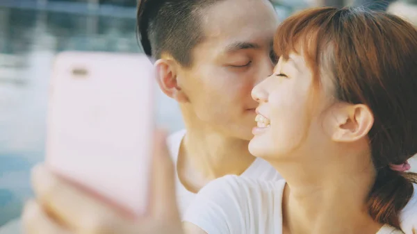 Asian couple using smart phone selfie