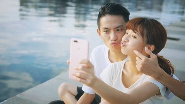 Asian couple using smart phone selfie