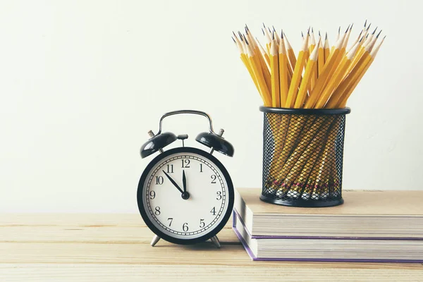 Close-Up Of Various Objects On Desk Against Wall