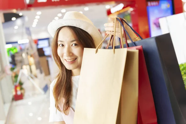 Asian Woman Holding Shopping Bags In Shopping Mall