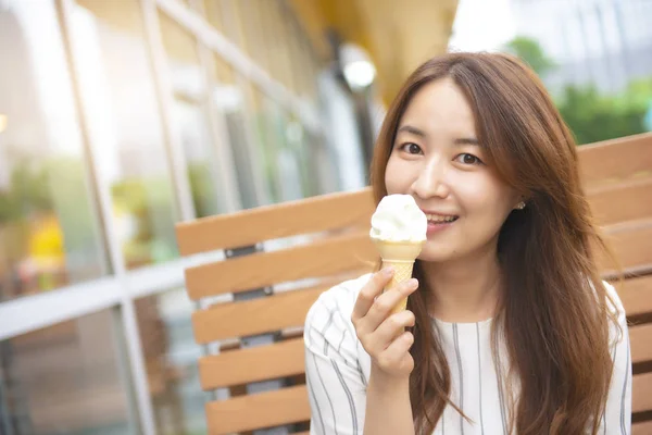 Pretty asian woman eating ice cream