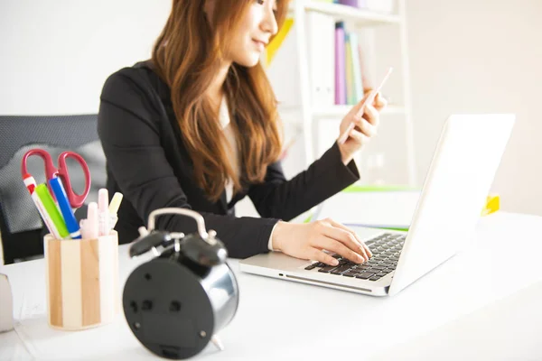 Businesswoman Using Mobile Phone At Desk In Office