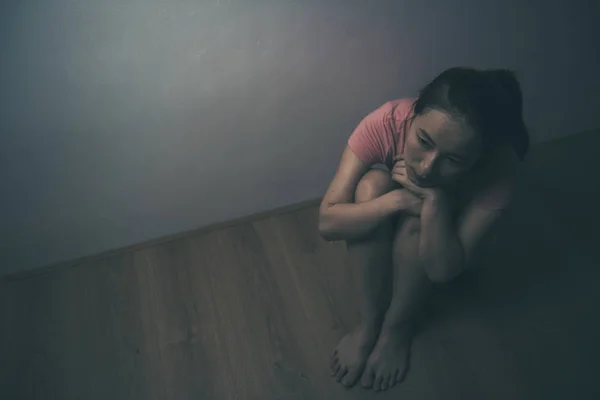 sad woman sitting alone in a empty room