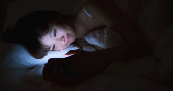 Woman Use Phone On The Bed at night