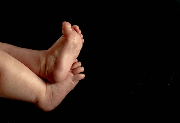 赤ちゃん足で黒前景で低キー効果画像 ロイヤリティフリーのストック写真