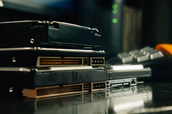 Ofis masasına yakın konnektörlü HDD yığını joystick cihazının düğmeleri ve arka planda wi fi modem yönlendirici yeşil ışık sinyalleri