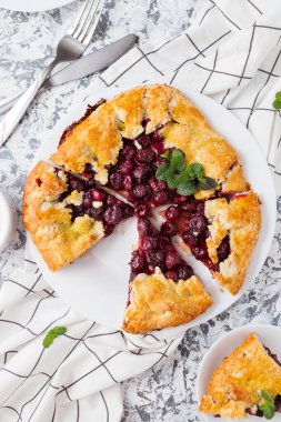 Beyaz tabakta taze kiraz ve peynirli ev yapımı turta.