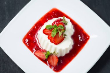 Kırmızı çilekli panna cotta, beyaz üzerine izole edilmiş.