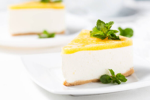 кусочек чизкейка с лимоном и базиликом на тарелке