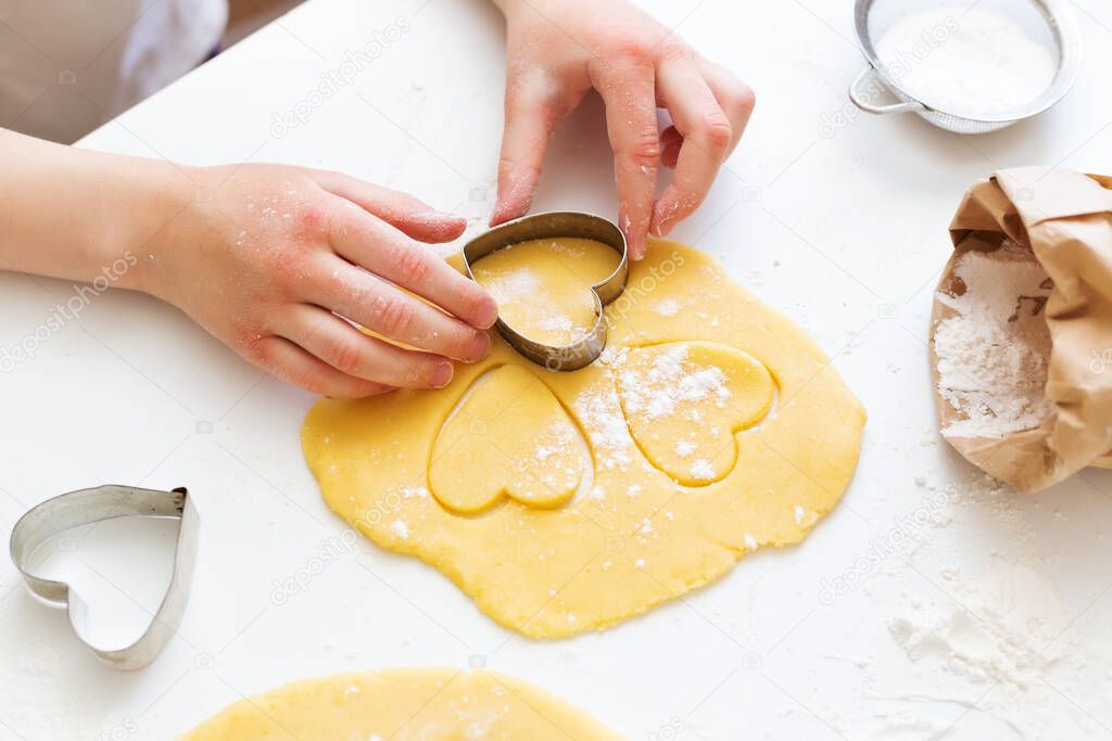 girl making  cookies with dough and cookie clutters 