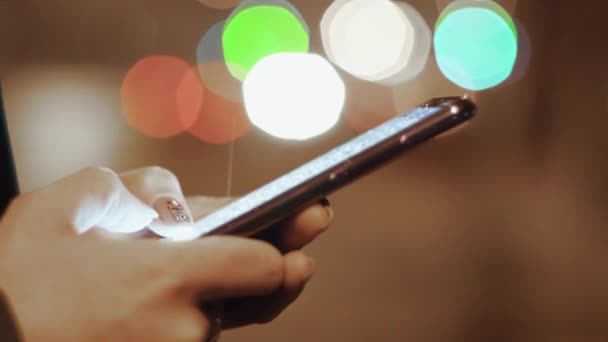 Main tenue prise de vue de femme à l'aide d'un smartphone la nuit Gros plan 