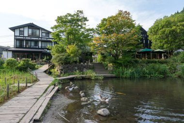 House, mağazalar ve kafeler sakin göl suya yansıtan kinrin göl boyunca. Yufuin, Japonya'da alınan