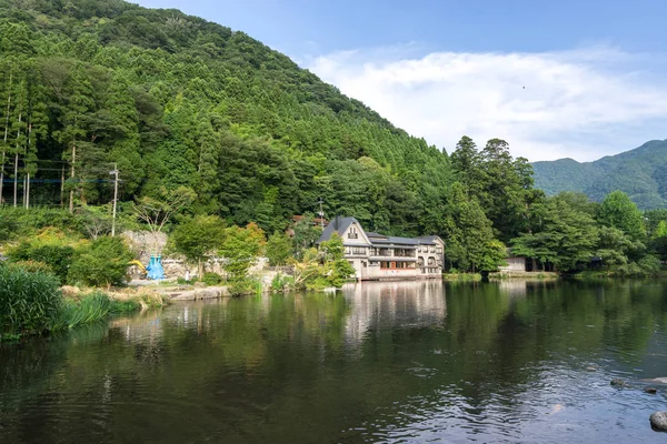 House, mağazalar ve kafeler sakin göl suya yansıtan kinrin göl boyunca. Yufuin, Japonya'da alınan