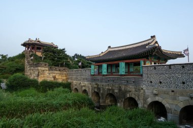 hwahongmun gate and surrounding park in suwon, south korea taken during sunset hours clipart