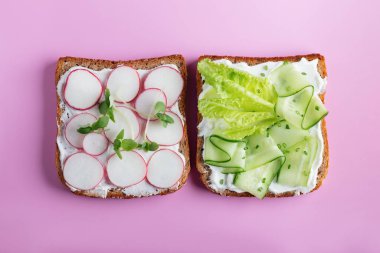 Makarna peynirli sandviç, salatalık, pembe arka planda turp. Üst Manzara. Boşluğu kopyala.