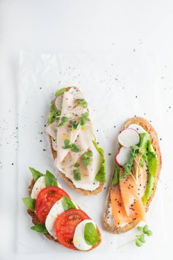 Jambonlu sandviç, turp, romantik salata, bebek fesleğen, mascarpone peyniri, beyaz arka planda Caprese salatası. kopyalama alanı. en üstteki görünüm.