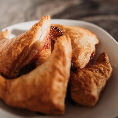 Ev yapımı puf böreği. Üçgen şeklinde ve karamelize şeker. Beyaz bir tabakta. Makro. Kapat