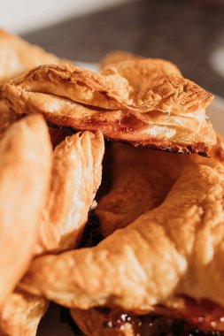 Ev yapımı puf böreği. Üçgen şeklinde ve karamelize şeker. Beyaz bir tabakta. Makro. Kapat