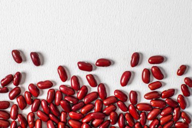 Kırmızı fasulyeler beyaz arka planda güzel bir şekilde serilmiş. Vejetaryen yemeği. Hazırlıksız.