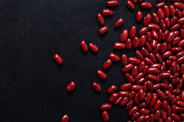 Siyah arkaplanda kırmızı fasulye. kopyalama alanı. En iyi manzara. Vejetaryen yemekleri. Hazırlıksız.