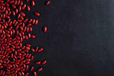Siyah arkaplanda kırmızı fasulye. kopyalama alanı. En iyi manzara. Vejetaryen yemekleri. Hazırlıksız.