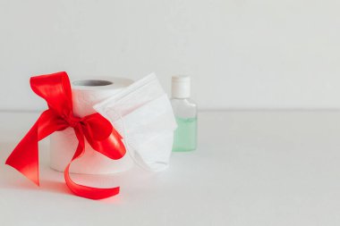 Beyaz arka planda kırmızı kurdeleli tuvalet kağıdı. Dezenfektan. Beyaz tıbbi maske
